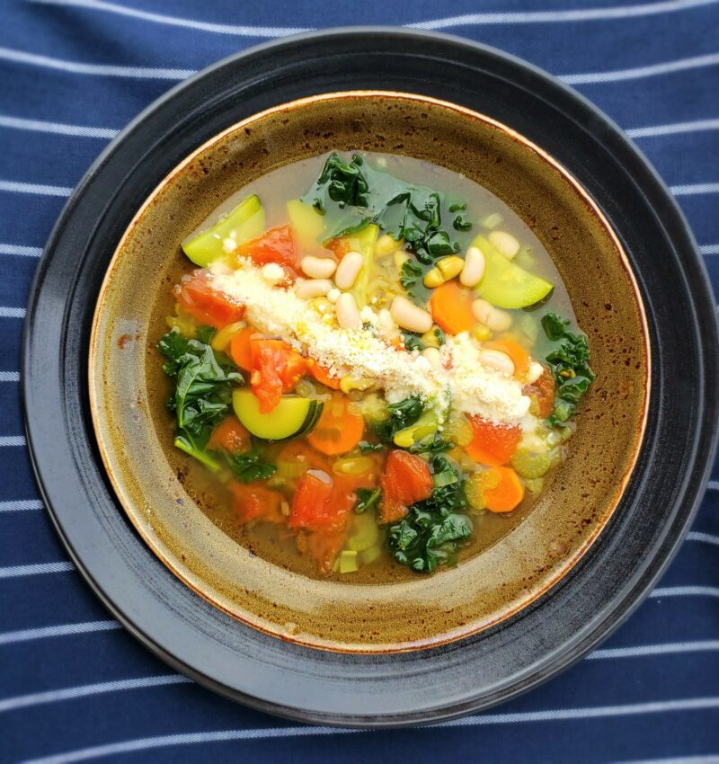 A bowl of Ribollita Soup with a pecorino cheese garnish