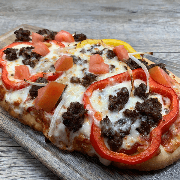 crumbled beef patty flatbread with peppers, onions and melted cheese